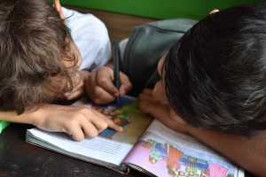 boys writing on book